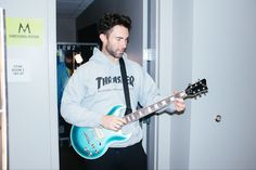 a man is playing an electric guitar in the hallway