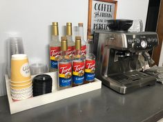 an espresso machine sitting on top of a counter next to some condiments