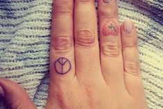 a woman's hand with two small tattoos on it