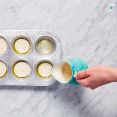 someone is pouring batter into a muffin tin