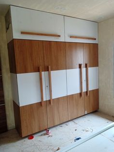 an unfinished room with wooden cabinets and white walls