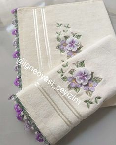 three white towels with purple flowers on them