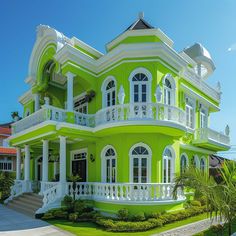 a large green and white house with balconies