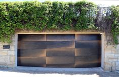 an iron garage door with ivy growing over it