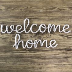 the word welcome home written in white yarn