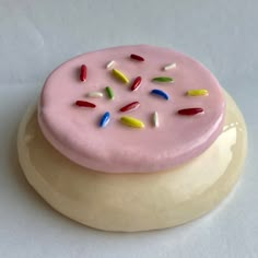 a pink cake with sprinkles sitting on top of a white plate