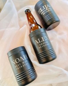 three personalized beer bottles sitting on top of a white cloth covered tablecloth,