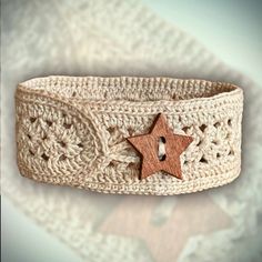 a crocheted bracelet with a wooden star on the front, and an embellishment in the middle