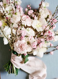 a bouquet of white and pink flowers on a blue surface with a cloth draped around it