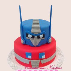 a red and blue cake with a transformer face on it's bottom layer