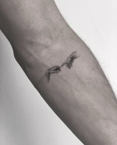 a black and white photo of a person's arm with a bird tattoo on it