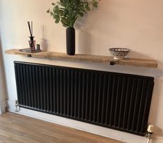 the radiator is next to a vase with flowers on it and a candle holder