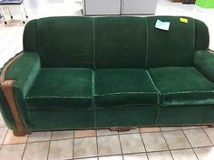 a green couch sitting on top of a tiled floor