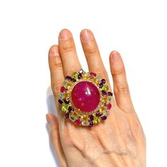 Cluster Multi Color Fancy Gems from Sri Lanka Ruby - 12 Carat Amethyst - 3 Carat Peridot - 2 Carat Blue Topaz - 2 Carat Citrine 3 Carat White Topaz - 1 Carat  This Ring is from the "Orient" traveling collection are the epitome of elegance and versatility. It offers a perfect blend of day to night and swimwear to evening wear, allowing you to effortlessly transition between different occasions and outfits. Wearing these spectacular oriental-style ring will undoubtedly make you the center of attention. It addw a touch of glamour and sophistication to your favorite caftans, swimwear, or evening attire, enhancing your overall look. The "Orient" collection, from which this ring originates, showcases exceptional craftsmanship and incorporates natural gemstones. The ring is set in 18k gold and si Elegant Multicolor Cabochon Gemstones, Luxury Multicolor Oval Gemstones, Ruby Party Ring, Party Ruby Ring, Luxury Multi-stone Ruby Ring, Yellow Gold Multi-stone Rings For Party, Luxury Multicolor Ruby Ring, Multicolor Ruby Jewelry For Formal Occasions, Luxury Handmade Ruby Ring