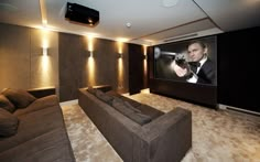 a large living room with two couches and a projector screen in the corner