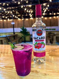 a bottle of bacardi next to a pink drink