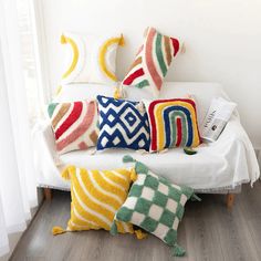 four colorful pillows on a white couch