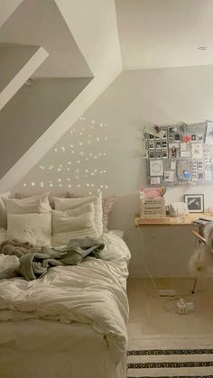 a bedroom with white bedding and lots of lights on the wall next to it