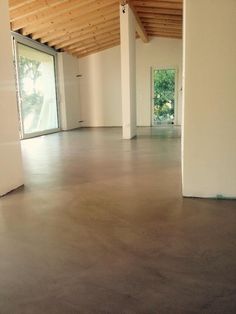 an empty room with wooden ceiling and white walls