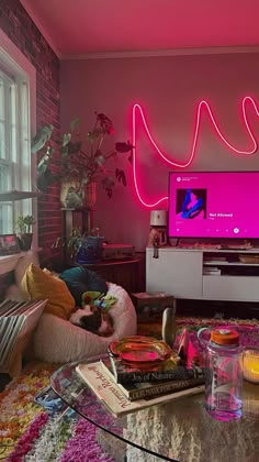 a living room filled with furniture and a neon pink light