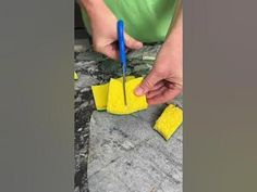 a person cutting pieces of yellow paper with scissors