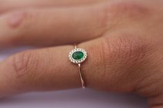 a woman's hand with a ring on it and a green stone in the middle