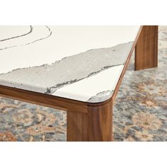 a marble top coffee table with wooden legs and an abstract design on the bottom surface