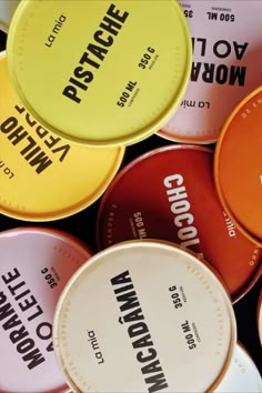 many different colored tins are stacked on top of each other, with the words choco written in black