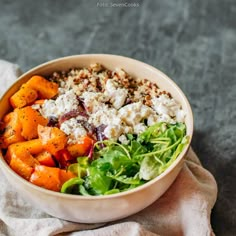 a salad with carrots, lettuce and feta cheese in a bowl