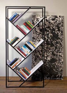 a book shelf with books on it next to a painting