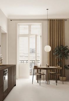 a kitchen with a table and chairs in front of a window next to a potted plant