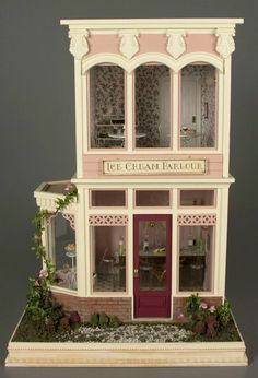 a doll house with pink and white trimmings on the front door, windows and doors