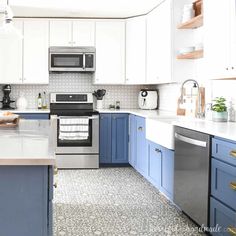 a kitchen with blue cabinets and stainless steel appliances