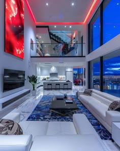 a living room with white couches and large windows overlooking the city at night time