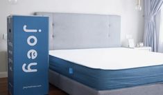 an open box sitting on top of a bed next to a blue mattress and headboard