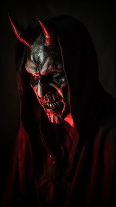 a man in a devil mask with red light on his face