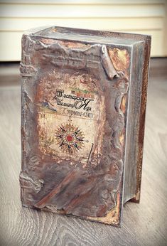 an old book sitting on top of a wooden table next to a window sill