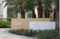 there is a sign that says torre 2 in front of some palm trees and bushes