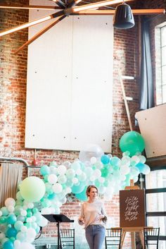 a woman is standing in front of balloons