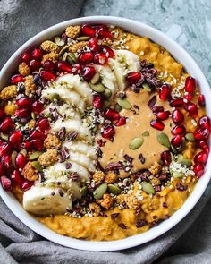 a white bowl filled with food and garnished with pomegranates