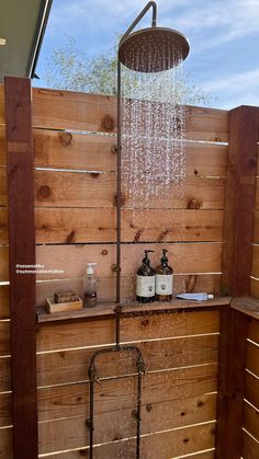 a shower head with water running from it and some wood planks on the side