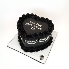 a black heart shaped cake on top of a white plate with the words once upon it