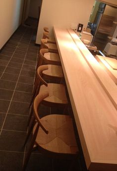 a row of chairs sitting next to a counter in a room with tile flooring