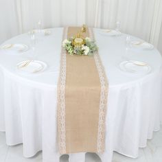 the table is set with white plates and place settings for two people to sit at