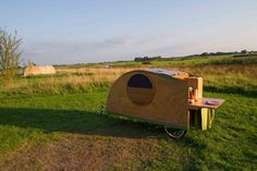 a small wooden structure sitting on top of a lush green field