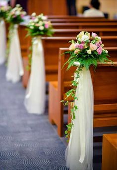 flowers are tied to the pews at a wedding ceremony in an empty church aisle