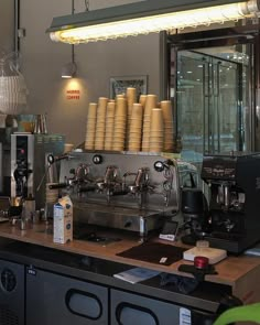 an espresso machine sitting on top of a counter next to a bunch of cups