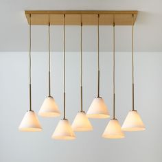 five lights hanging from a ceiling in a room