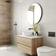 a bathroom with a toilet, sink and mirror in it's center piece is shown