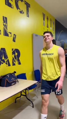 a man standing in front of a yellow wall